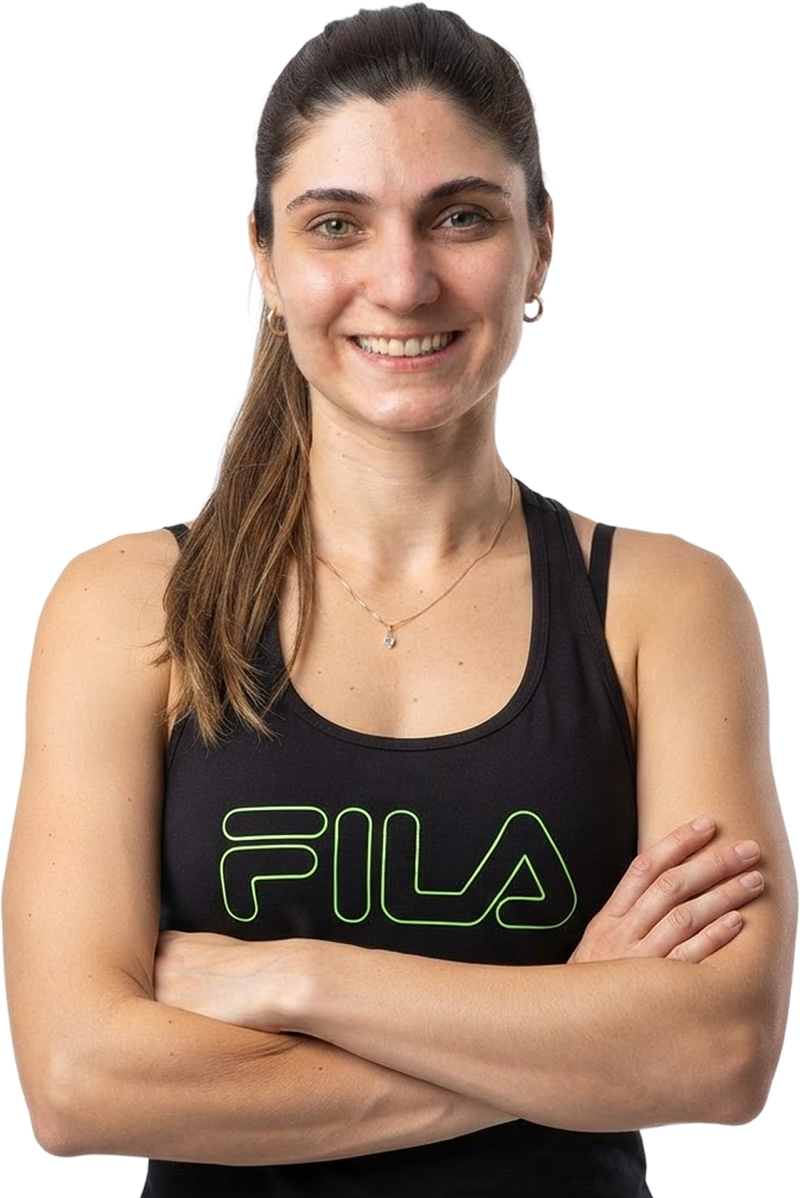 Aline Pelegrini, personal trainer, sorrindo de braços cruzados.